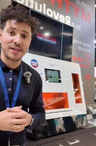 Sam standing at the front of the CORiTEC Mythos at IDS Cologne.